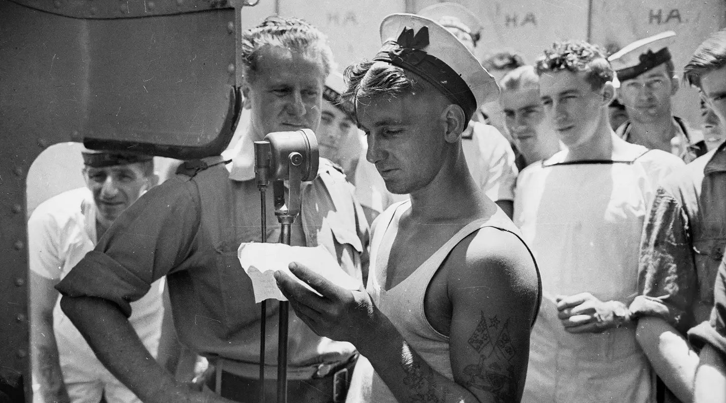 Lawrence H. Cecil of the ABC, recording messages home on board HMAS Perth, 1941. 