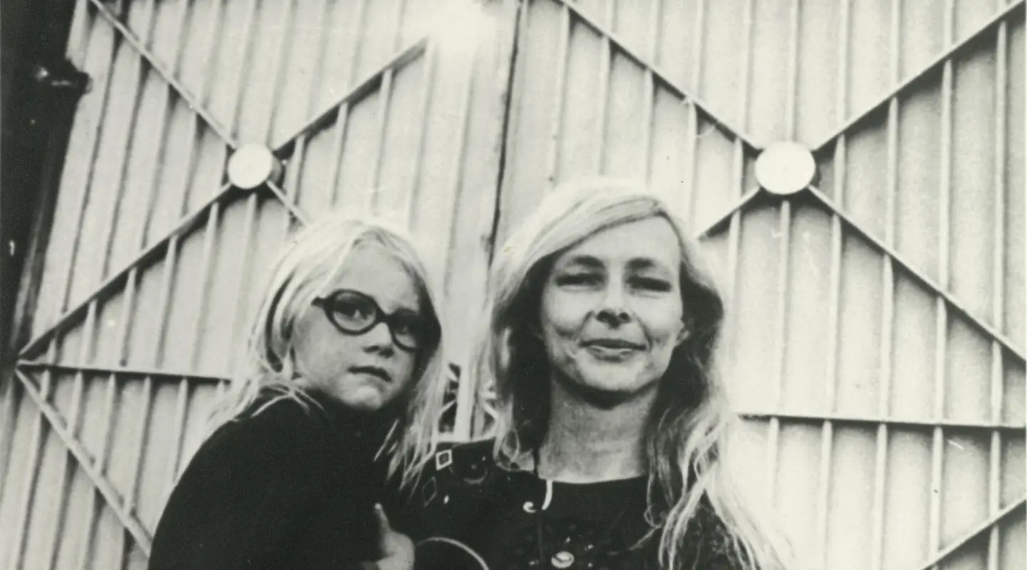 Jean McLean carries a young girl on her hip