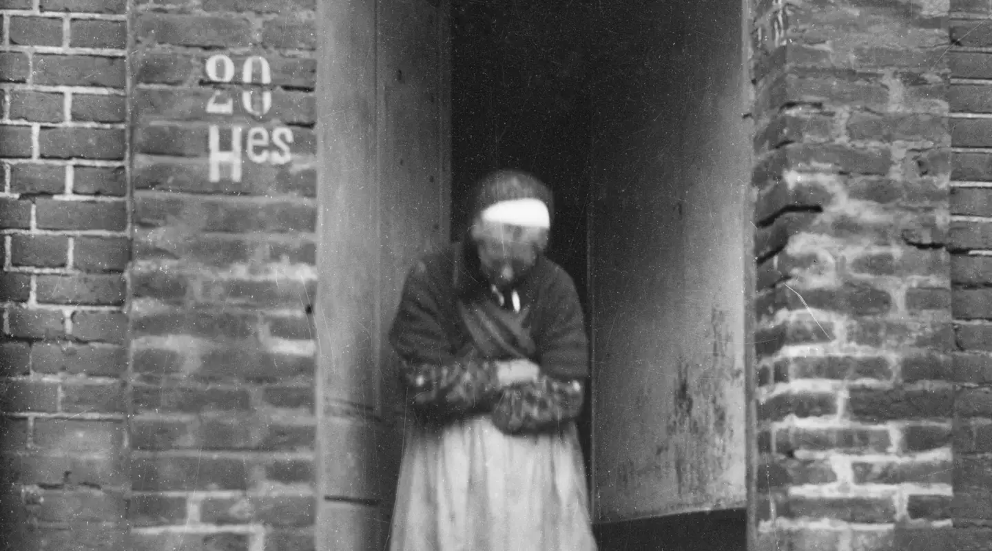 An old Frenchwoman at the entrance to her brick house, Villers-Bretonneux