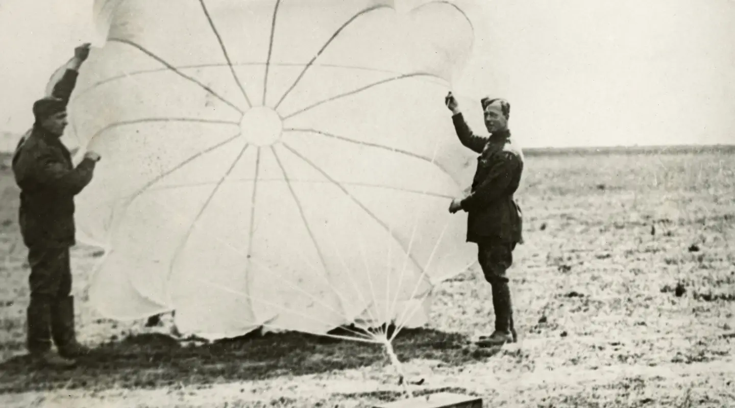 Members of No. 3 Squadron with one of the parachutes for dropping ammunition. 