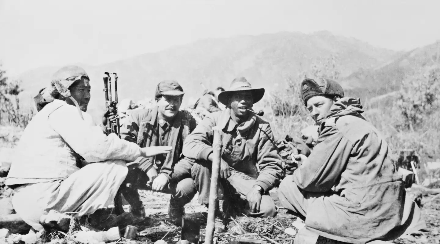 Three members of the 3rd Battalion, The Royal Australian Regiment (3RAR), confer with a North Korean interpreter (left) who is serving with the battalion. Saunders is second from the right, smoking a pipe.