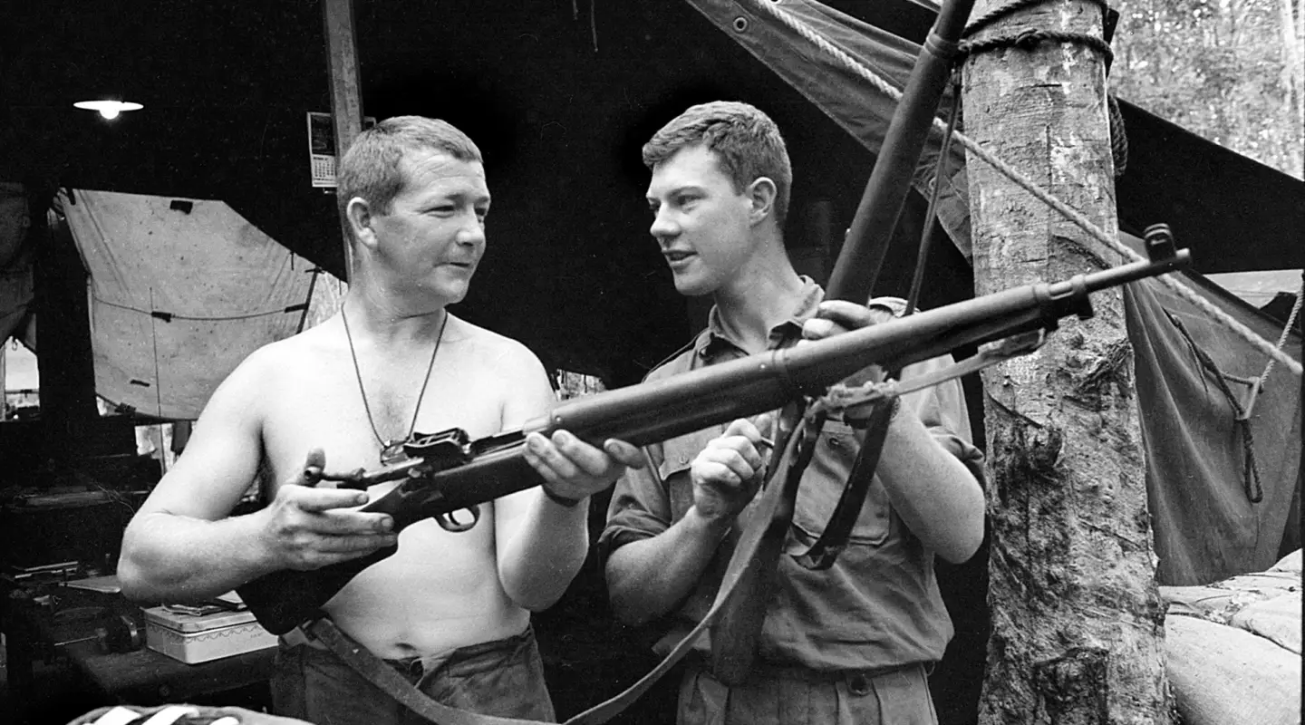 Sergeant Brian Walsh and 2nd Lieutenant Jim Fitzsimon, both of 7RAR, checking an American .30-06 calibre M1917 rifle and a 7.92-mm German Mauser Model 98