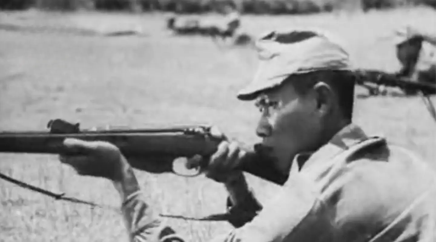Japanese soldier points gun during military training video