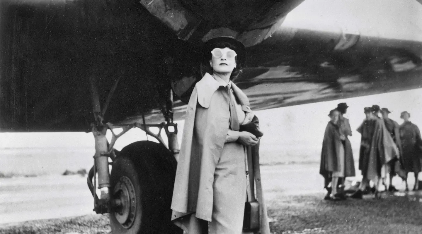 Iris Dexter standing under the starboard engine of a Doughlas C-47 aircraft. Photograph by Barbara Isaacson.