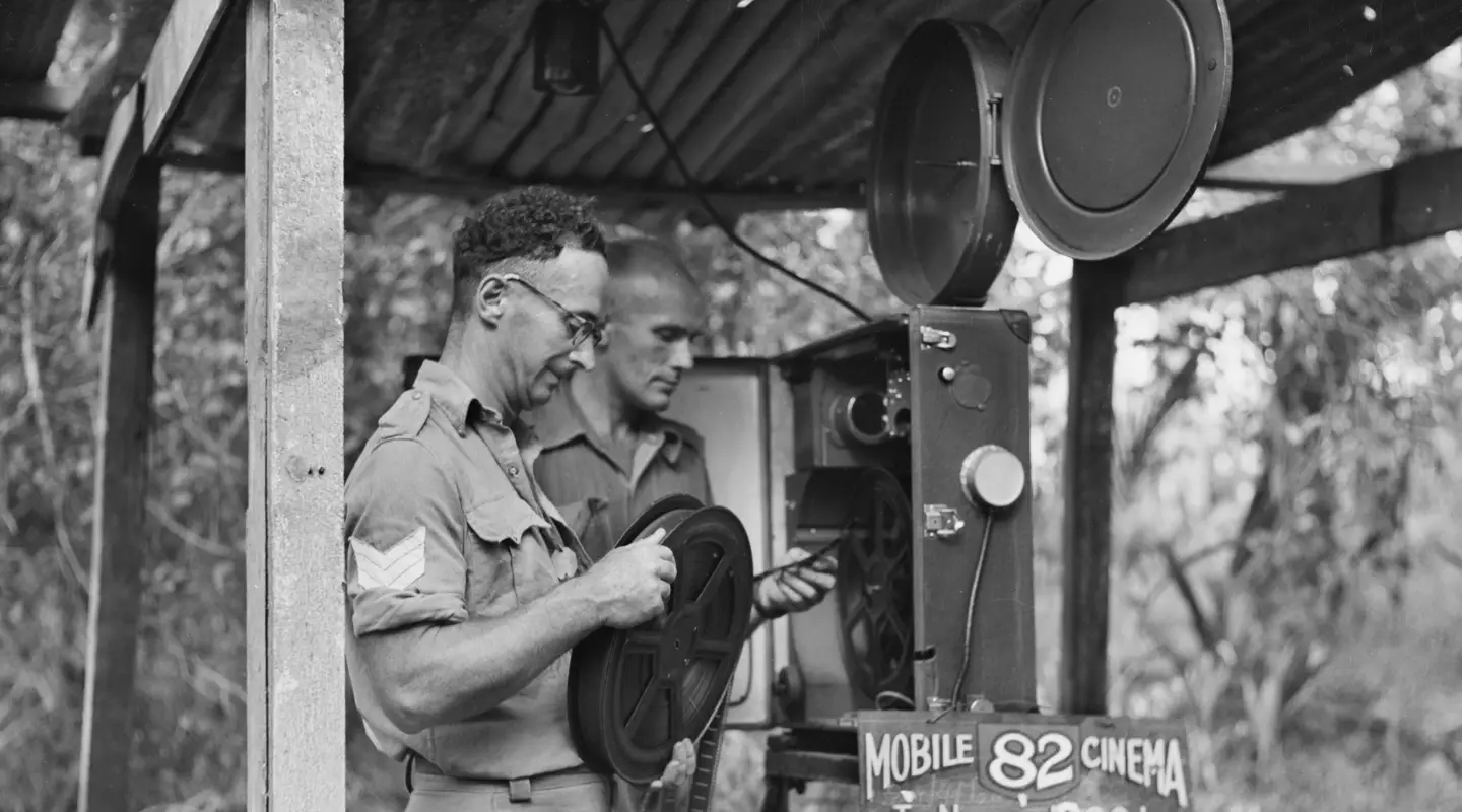 Members of Mobile Cinema Unit 82 prepare their projector before an evening show, New Britain, 1945.