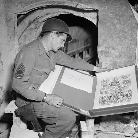 A serviceman looks at stolen loot at Merker salt mine, 13 May 1945.