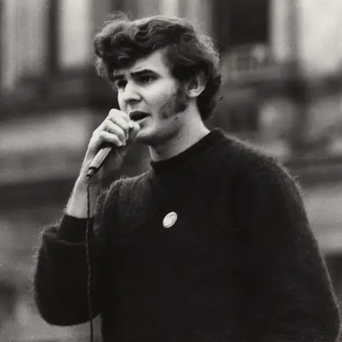 Lynn Arnold speaks into a microphone 