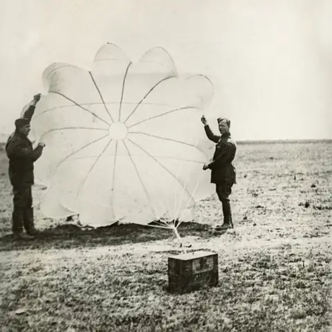 Members of No. 3 Squadron with one of the parachutes for dropping ammunition. 