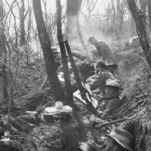 Members of the Intelligence (or Sniper) Section sit in a shallow trench