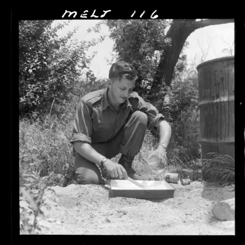 25178 Private John Longstaff mixing developer outside the unit darkroom