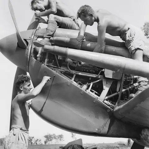 Four ground crew checking the engine of a Supermarine Spitfire aircraft of No.54 Squadron, RAF