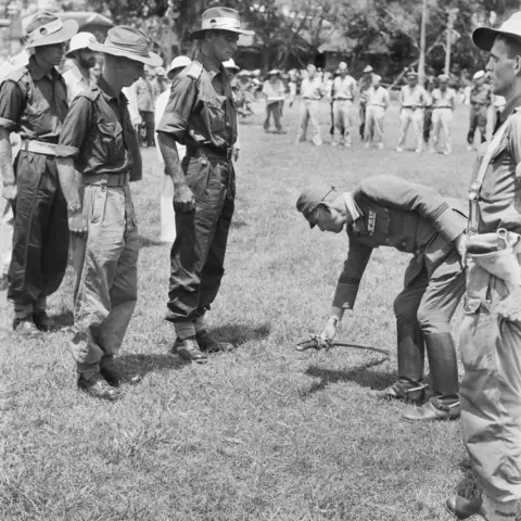 Major General Uno lays his sword