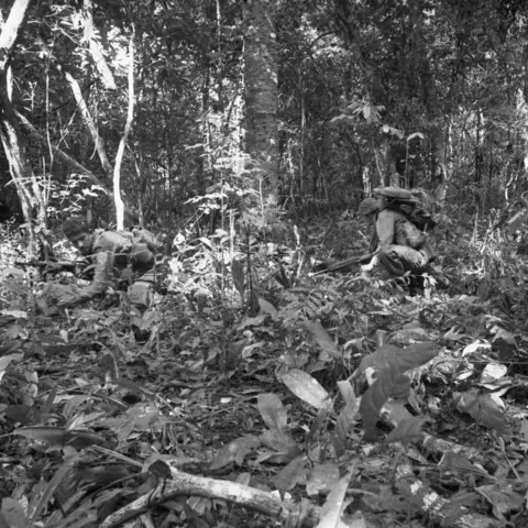 Soldiers of A Company, 8RAR, move up to assault an enemy bunker complex in densely timbered country 