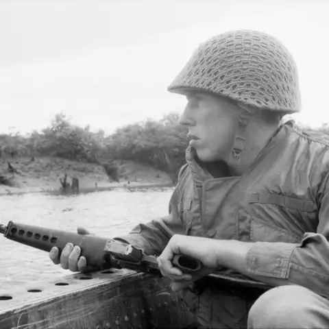 Private Len Reeve of Manjimup, WA, scans the riverbank for signs of Viet Cong. 