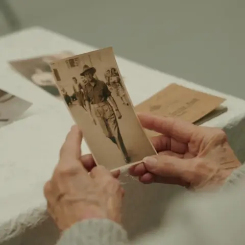 John’s niece, Rae Maree Curtis, studies a photograph of her uncle.