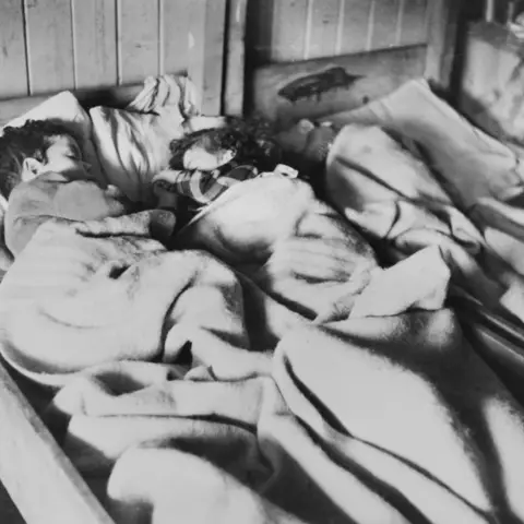 Children sick with typhus sleep together in the concentration camp.