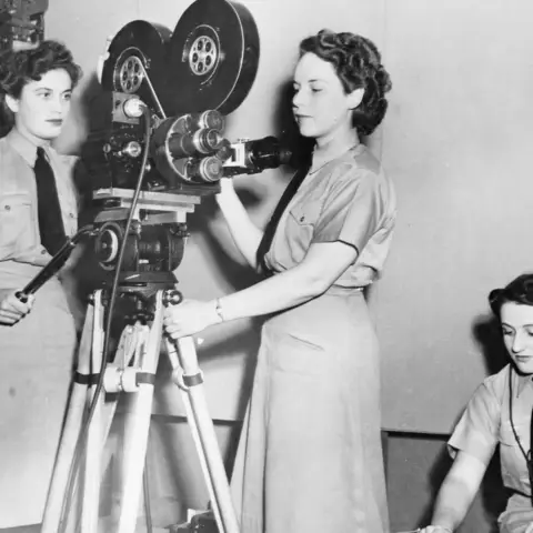 Two unidentified WAAAF photographers operate a motion picture camera