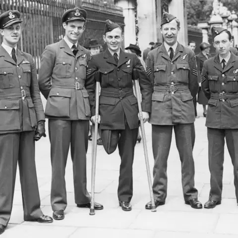 Group portrait of Flight Sergeant G. Charles Chapman-Smith CGM, of Sydney, NSW (centre) with members of his crew outside Buckingham Palace.