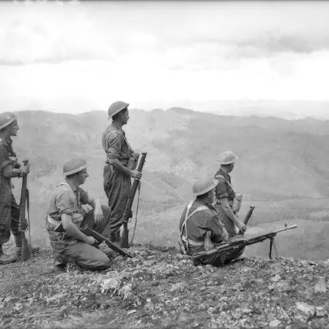 A patrol from the 39th Australian Infantry Battalion looking out over the Uberi Valley.