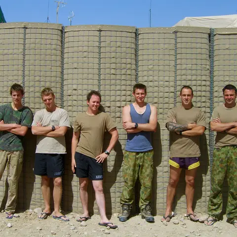Informal group portrait of personnel from the Operational Mentoring and Liaison Team in a mix of their uniform and casual wear.