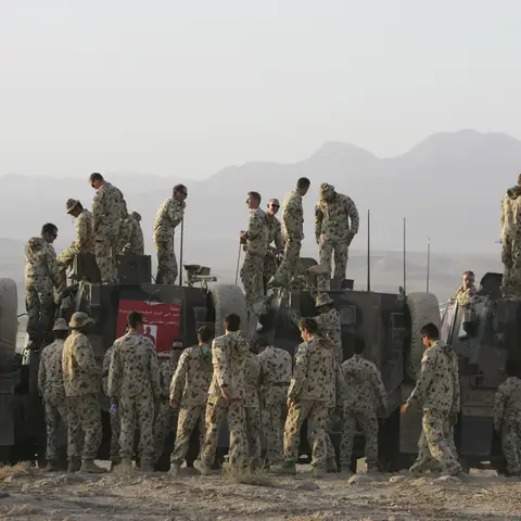 Members of Reconstruction Task 4 (RTF-4), including 3RAR prepare for a group photograph at Camp Holland