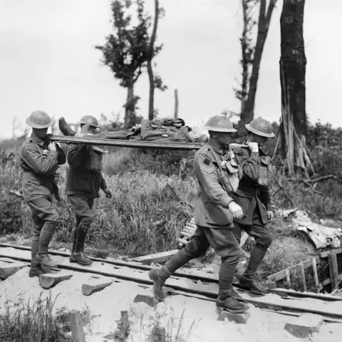 Four unidentified stretcher bearers of the 2nd Australian Division carrying a wounded soldier