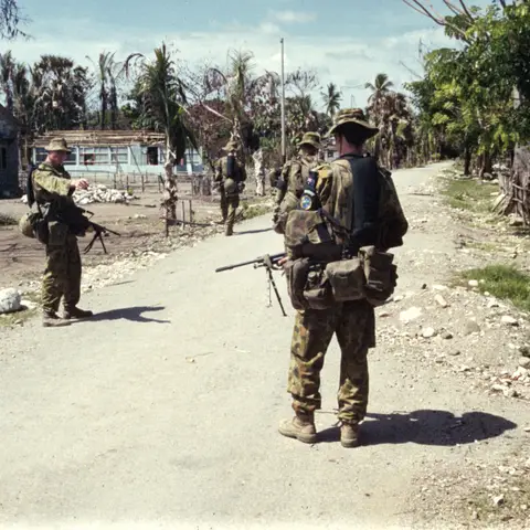 Gunner Craig Hall (left) of the 108th Battery, 4th Field Regiment, part of Interfet talking to Gunner Sage (back to camera) on patrol
