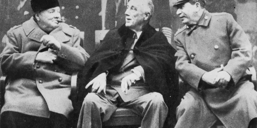 Three men seated in a row.