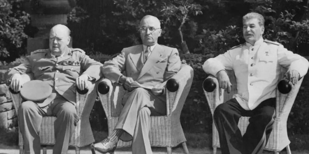 Three men seated in a row.