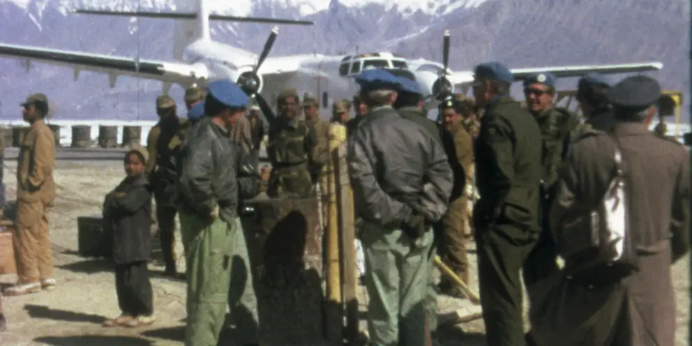 Members of the United Nations Military Observer Group in India and Pakistan (UNMOGIP) wait to board a Caribou aircraft flown by members of No. 38 Squadron, RAAF.