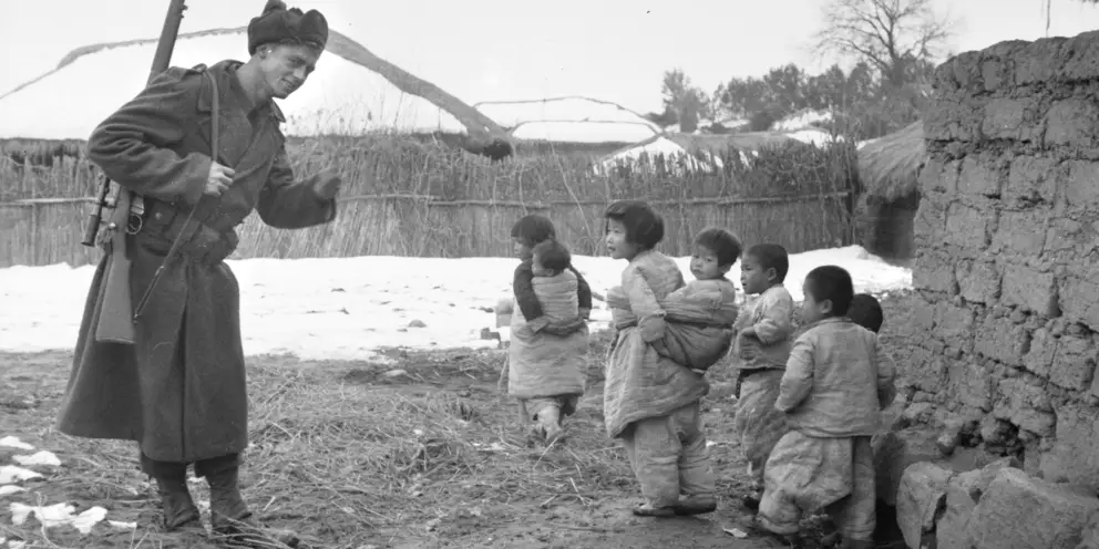 Private Chris Bell-Chambers, 3RAR, smiles and waves to a group of Korean children