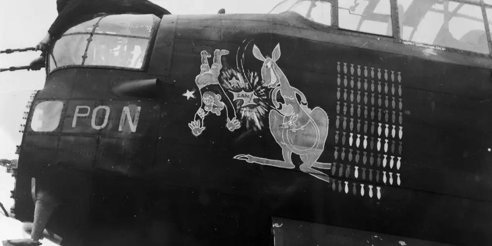 Lincolnshire, England. 1944-12-06. "N" for Nuts, a Lancaster bomber aircraft of No. 467 Squadron RAAF at RAF Station Waddington, which has completed 87 operations. The white bombs represent daylight raids. Its insignia shows the boxing kangaroo, with young one in pouch, "zamming" Adolf Hitler. AWM UK2254
