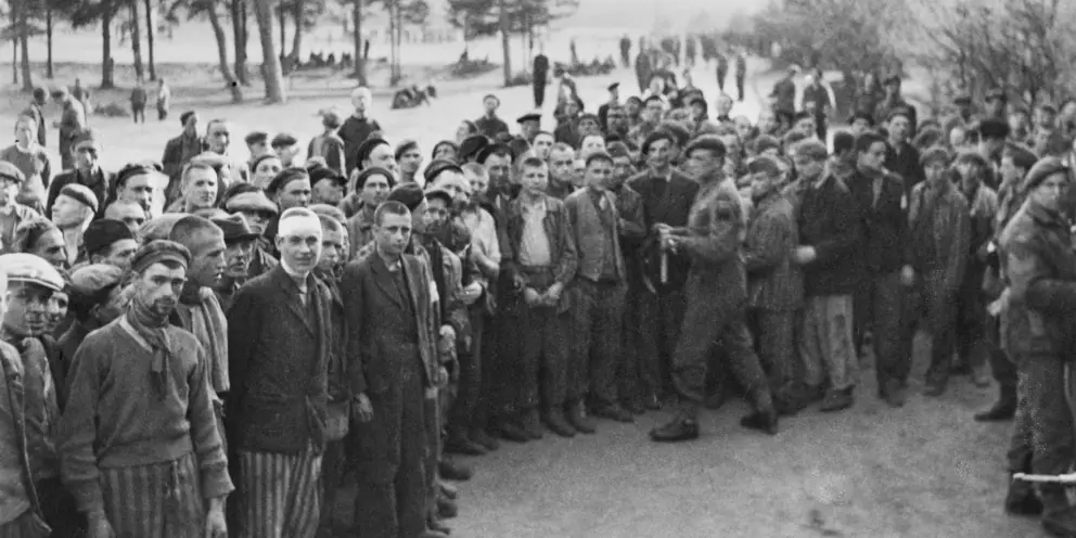 A crowd of male inmates of Belsen concentration camp gathered as British soldiers arrived.