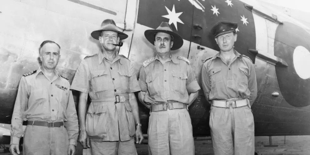 Three of the first four Australian peacekeepers stand in front of an aircraft with Charles Eaton.