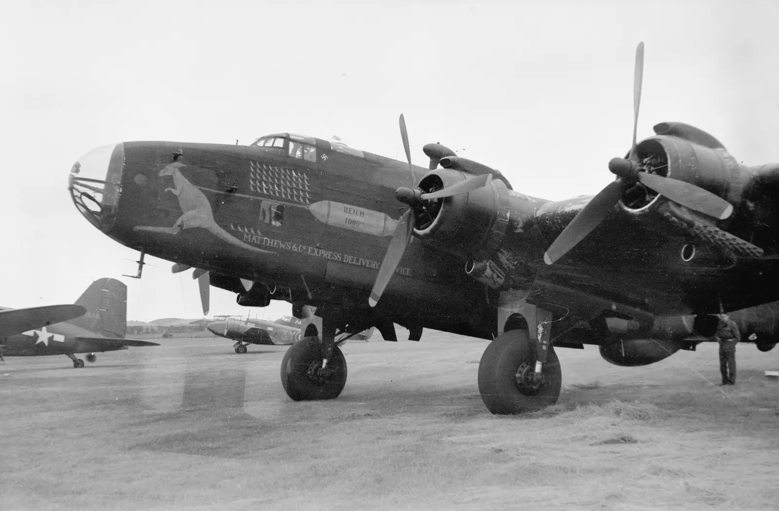 A Handley Page Halifax B Mark III aircraft of 192 Squadron, RAF, showing some impressive nose art, consisting of a large kangaroo, a large bomb titled 'Reich 1,000' and a printed slogan, 'Matthews' & Co. Express delivery service'. This aircraft was piloted by James Matthews, RAAF, and has completed 55 operations represented by the rows of small kangaroos painted on the side. It has also shot down a German aircraft denoted by the swastika painted behind the pilot's side window. AWM P01523.017