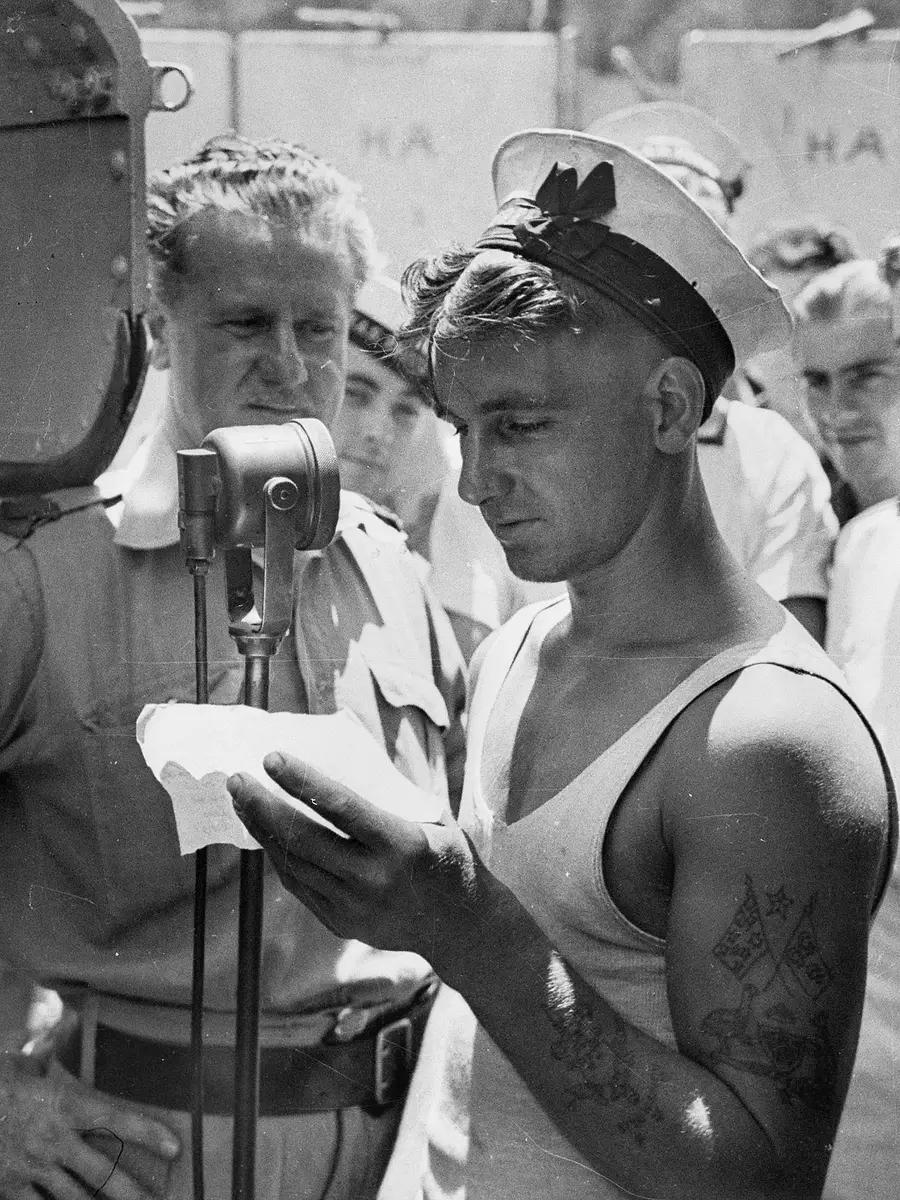 Lawrence H. Cecil of the ABC, recording messages home on board HMAS Perth, 1941. 