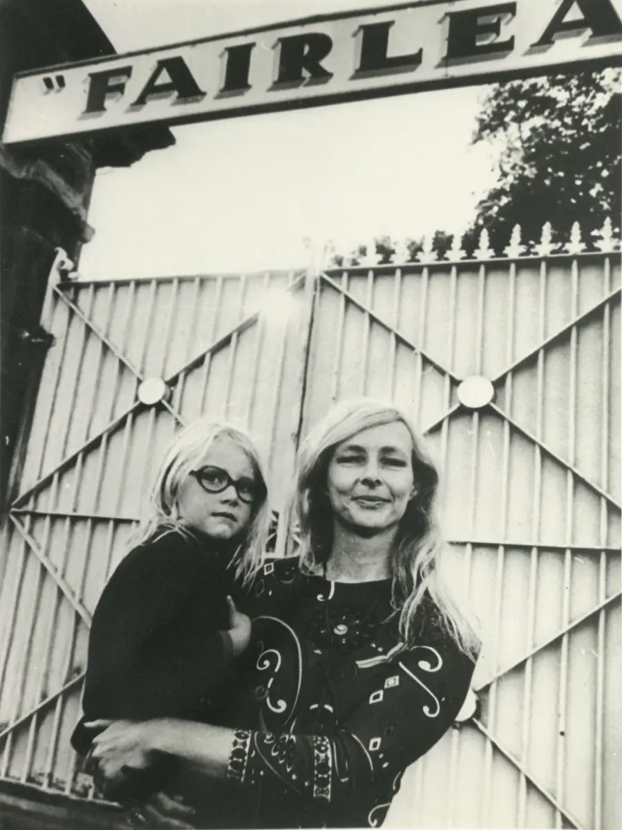 Jean McLean carries a young girl on her hip