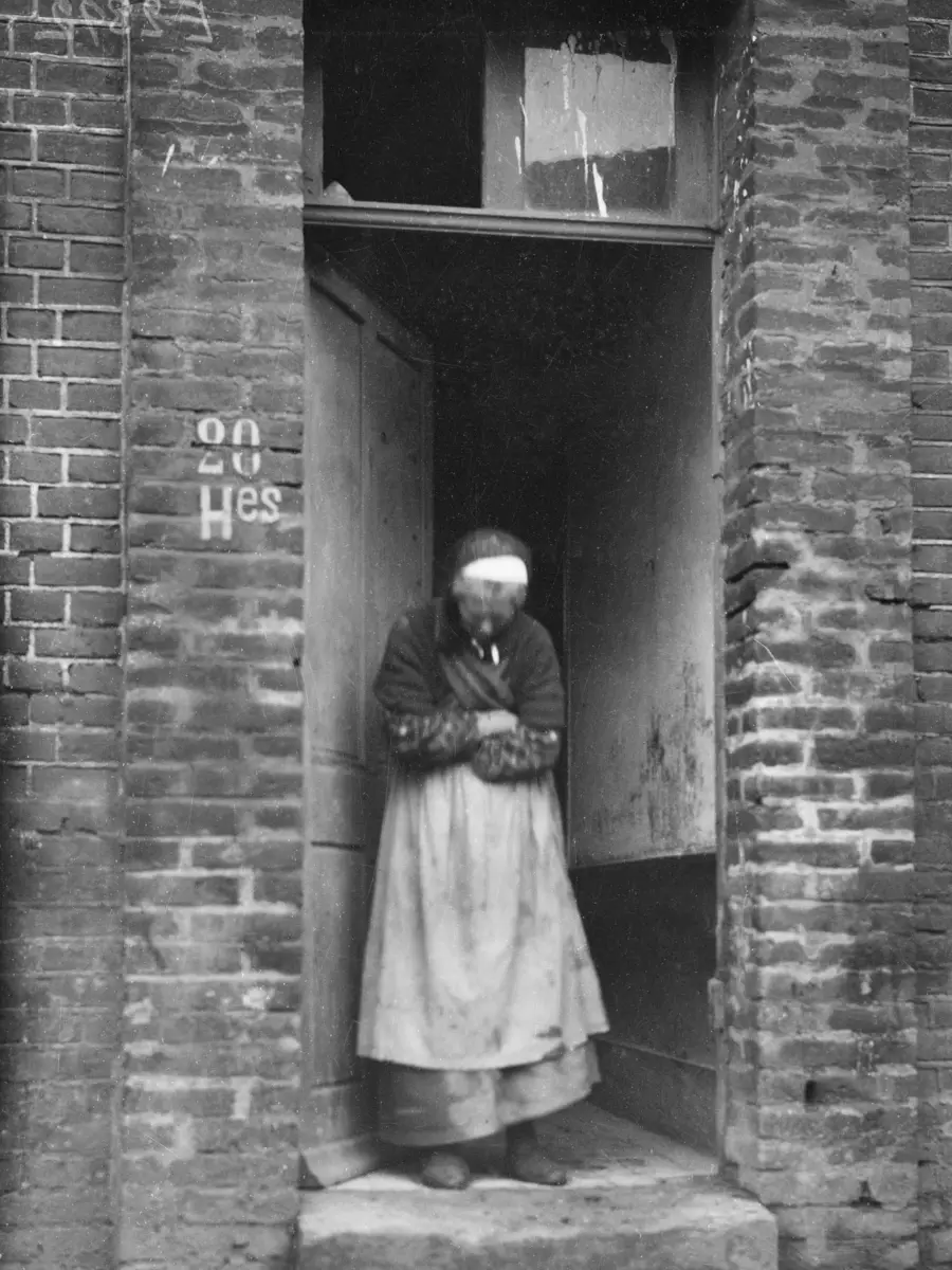 An old Frenchwoman at the entrance to her brick house, Villers-Bretonneux
