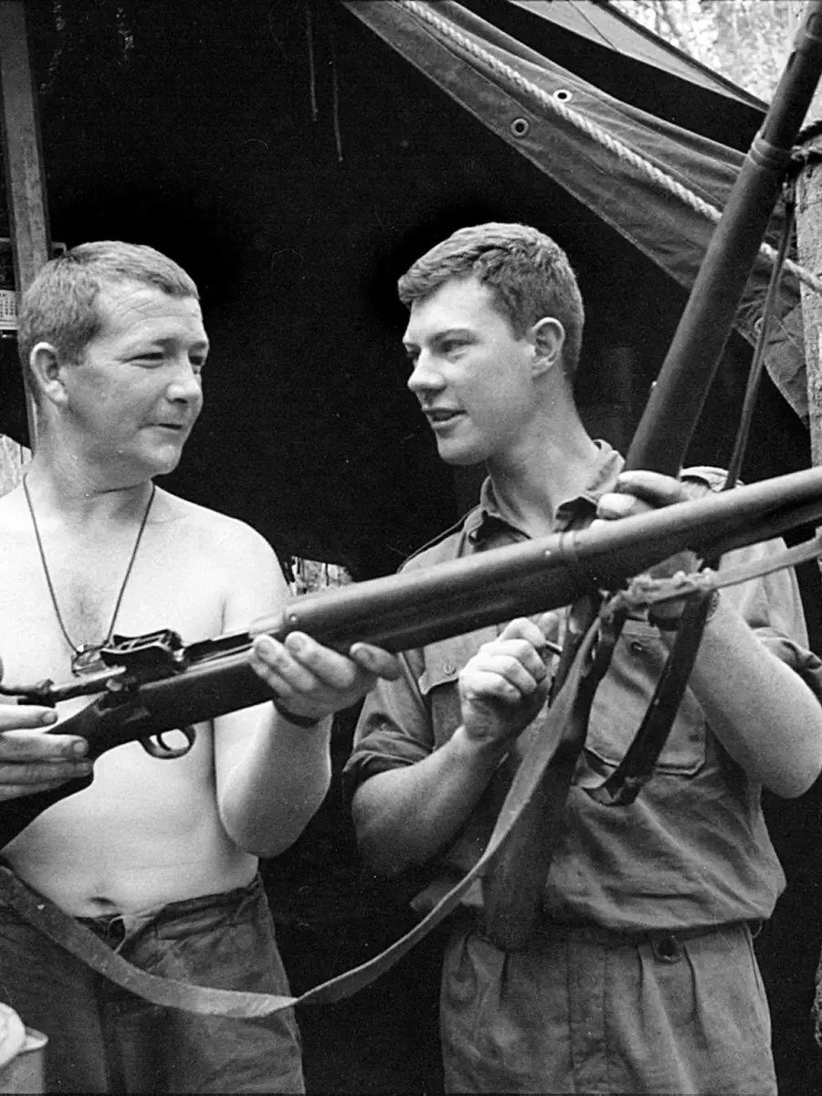 Sergeant Brian Walsh and 2nd Lieutenant Jim Fitzsimon, both of 7RAR, checking an American .30-06 calibre M1917 rifle and a 7.92-mm German Mauser Model 98