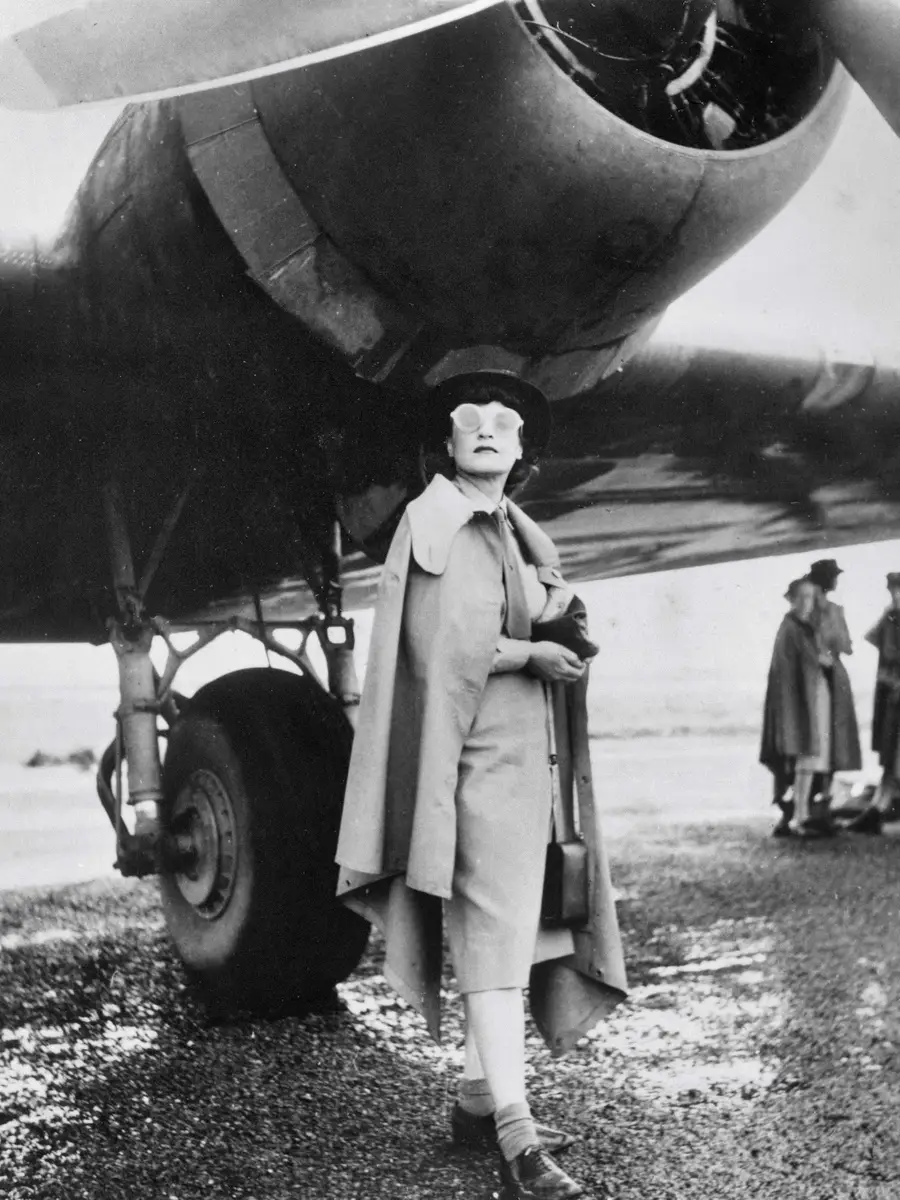 Iris Dexter standing under the starboard engine of a Doughlas C-47 aircraft. Photograph by Barbara Isaacson.