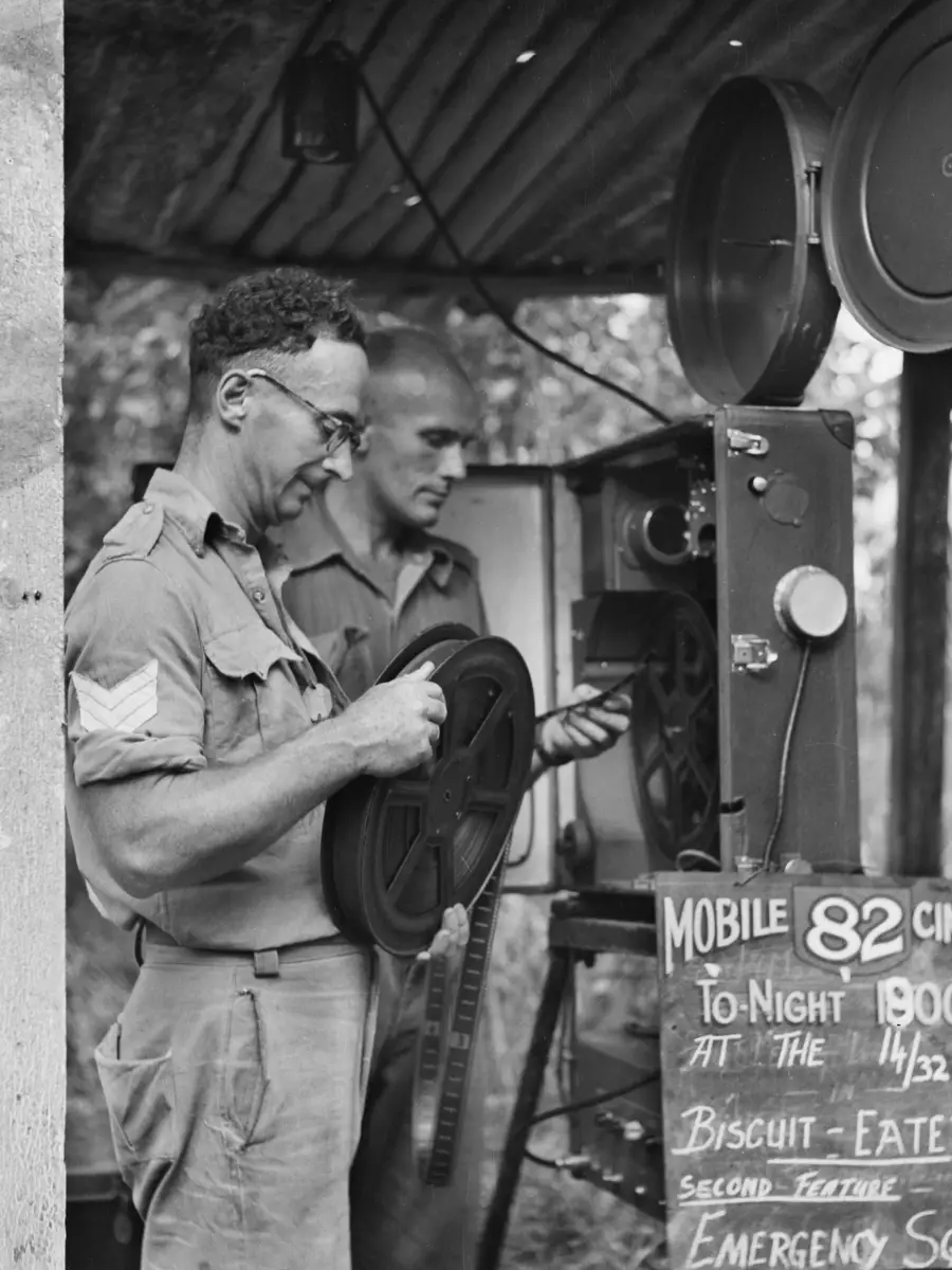 Members of Mobile Cinema Unit 82 prepare their projector before an evening show, New Britain, 1945.