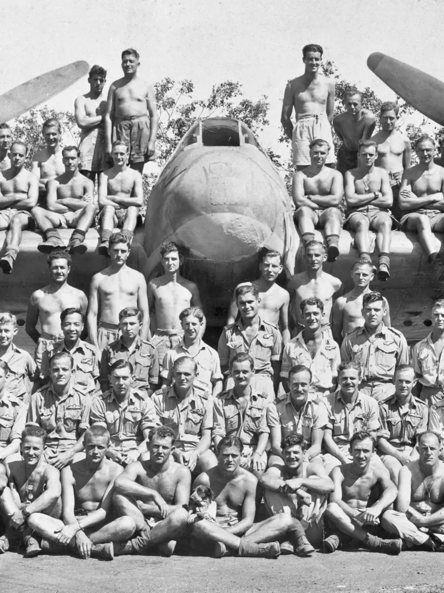 Group portrait of members of No 31 Squadron RAAF assembled on and in front of one of the unit's Bristol Beaufighter aircraft.