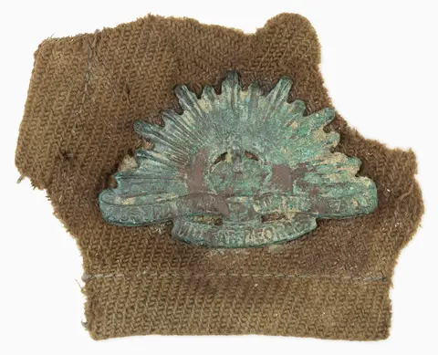 Remains of a Rising Sun badge from the left collar of an Australian tunic