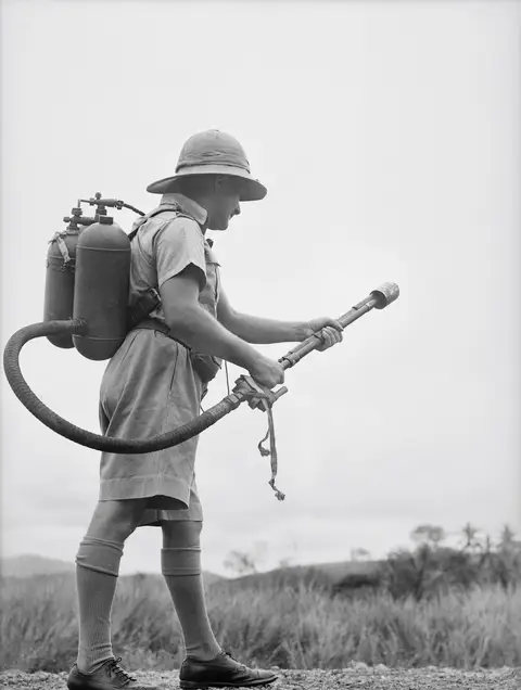 A man holds a flamethrower