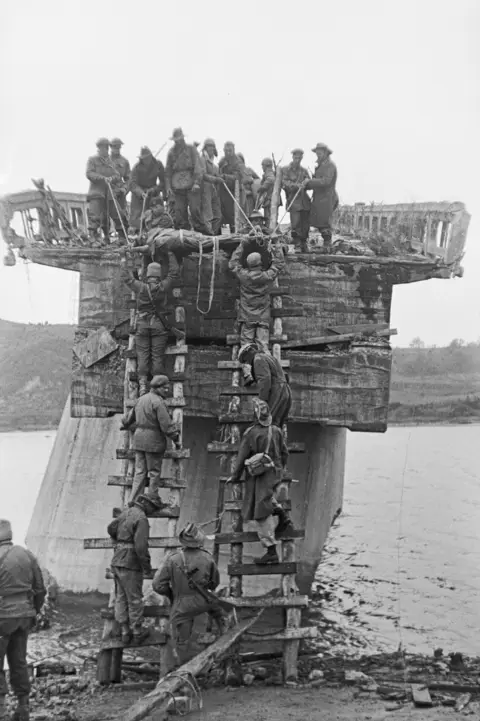 A wounded 3RAR soldier is lowered from the “broken bridge” across the Taeryong River. 