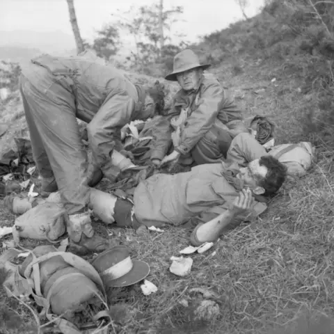 5 November 1950, Pakchon. Sergeant Tom Murray GM, a stretcher-bearer and 3RAR’s drum major, tends the wounds of Private Gerry O’Connell