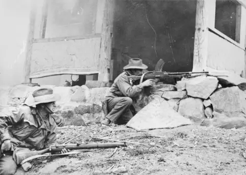. November 1950Two unidentified members of 3RAR clearing a village, possibly Pakchon.  AWM HOBJ1662