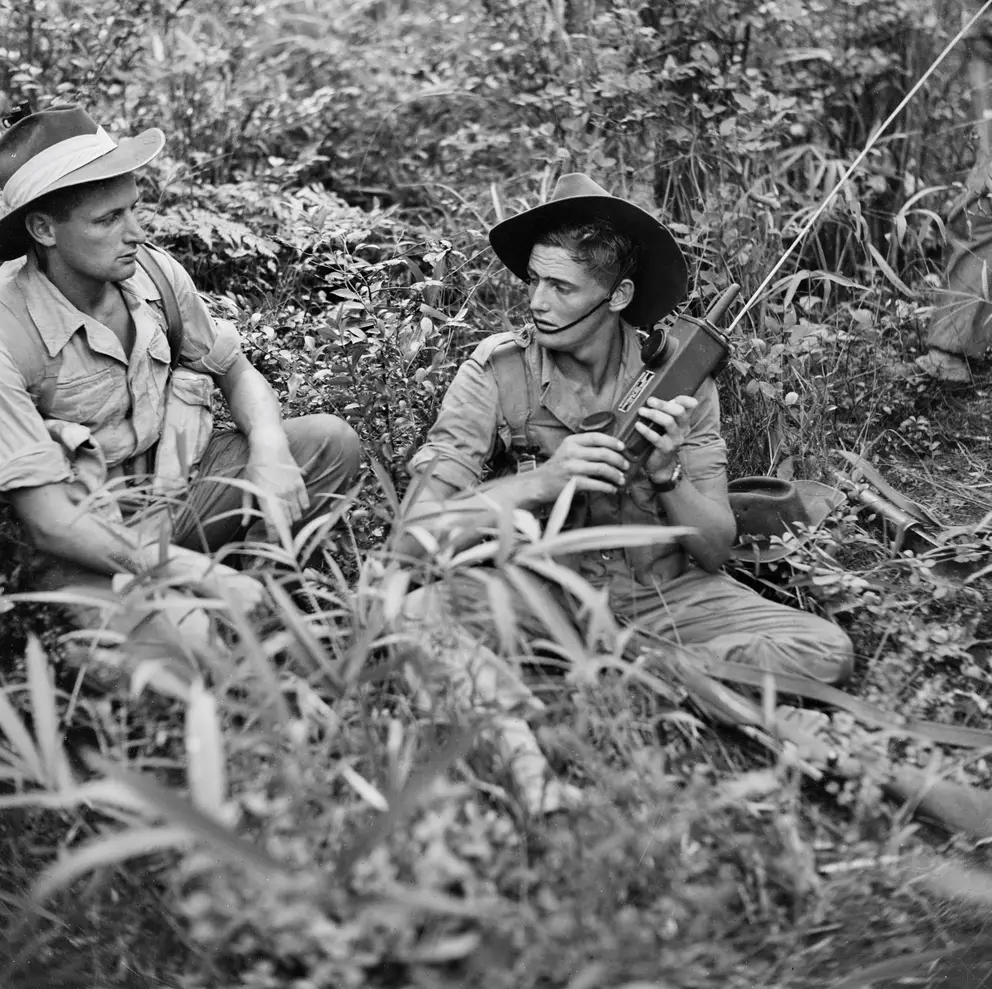 Sergeant Jack Harris (left) sits with another servicemen gathering intelligence.