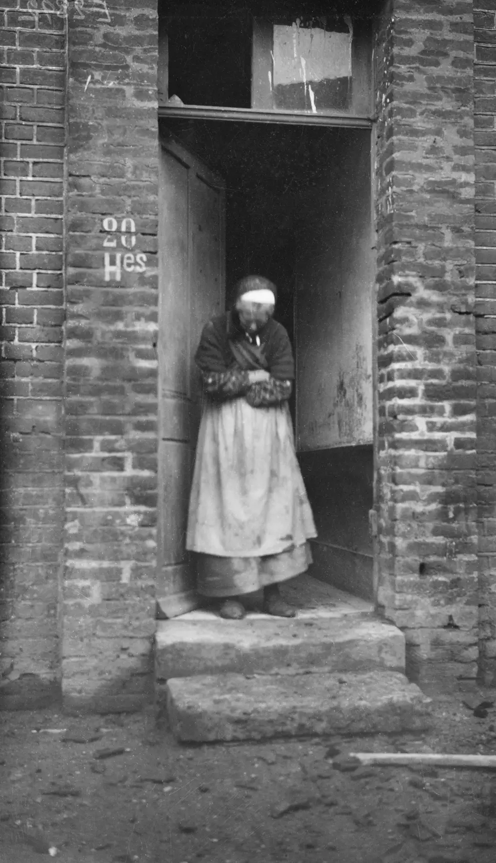 An old Frenchwoman at the entrance to her brick house, Villers-Bretonneux