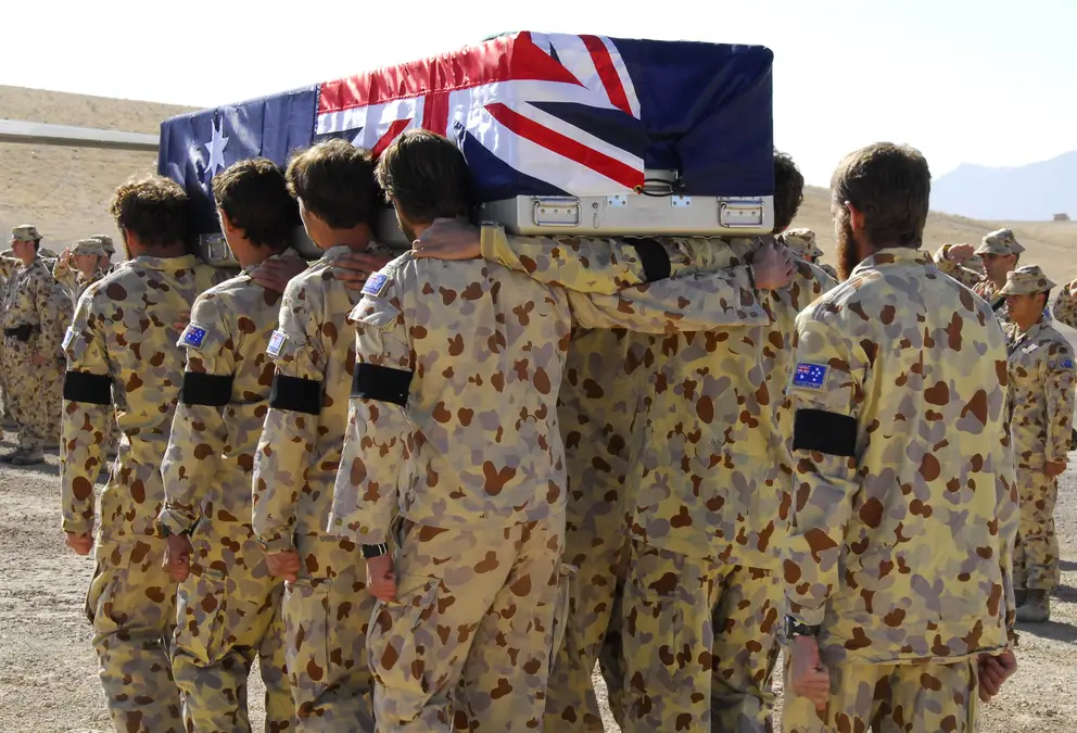 Australian soldiers carry the coffin of Private Luke Worsley. The coffin is shrouded in the Australian flag. 